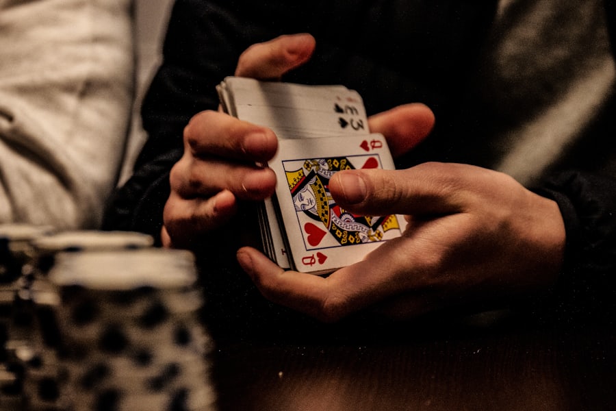 Tangan memegang kartu king sekop di atas meja poker