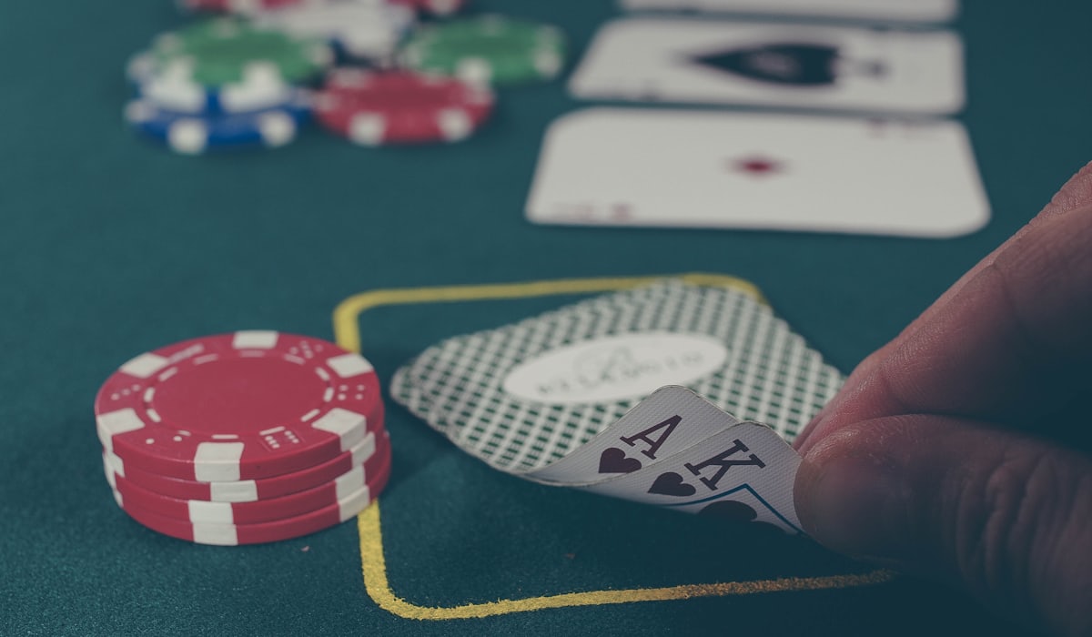 Tangan memegang kartu as dan raja di atas meja poker